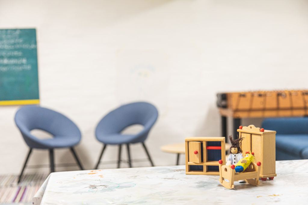 Oleskelutila, jossa on kaksi tuolia ja pöydällä leluja