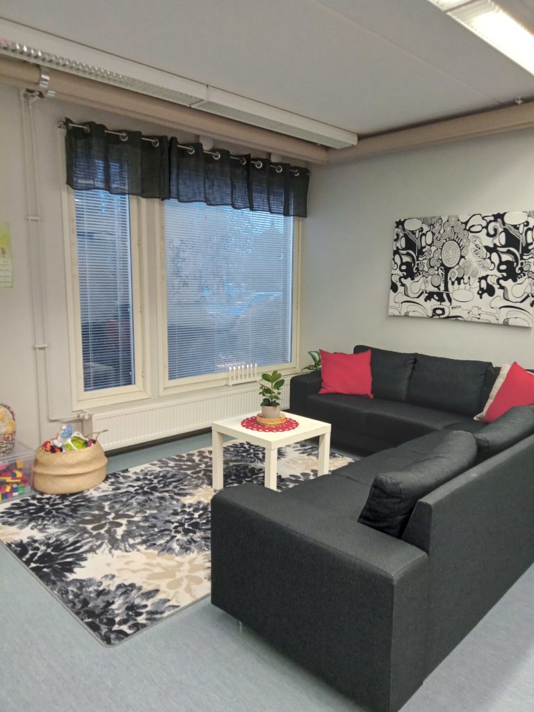 Oleskeluhuone, jossa on isot ikkunat ja iso kulmasohva