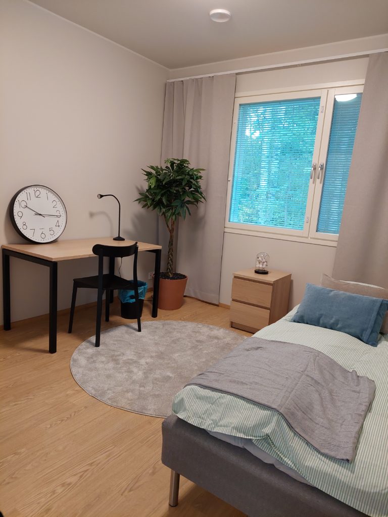 Iso makuuhuone sängyn ja kirjoituspöydän kanssa