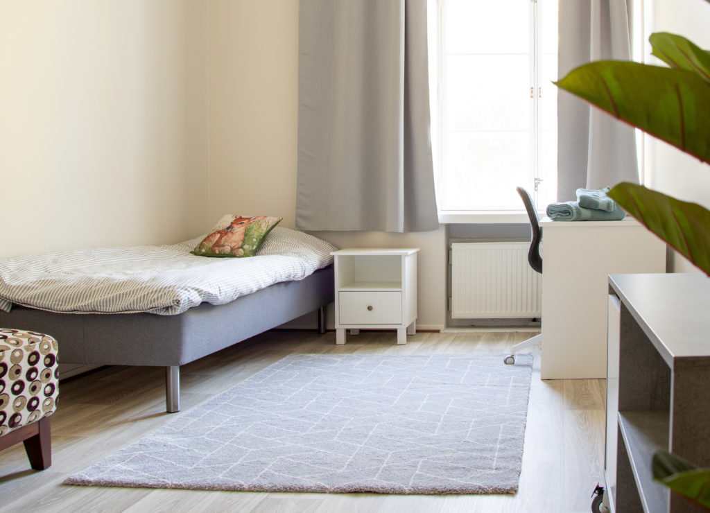 Eemelin Kissankulman yksi huone, jossa näkyy sänky, yöpöytä, matto