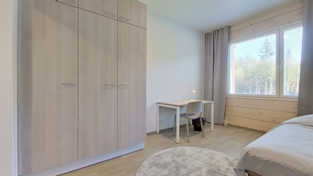 Sovrum med garderob, arbetsbord och säng
