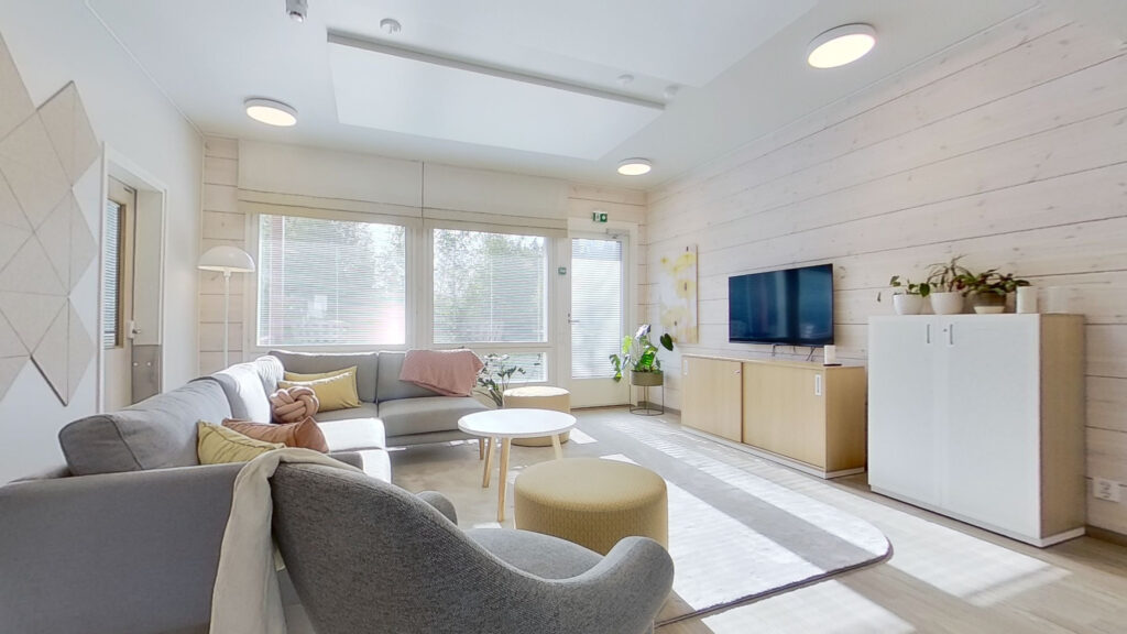 Stort och ljust vardagsrum med en stor soffa, soffbord och TV