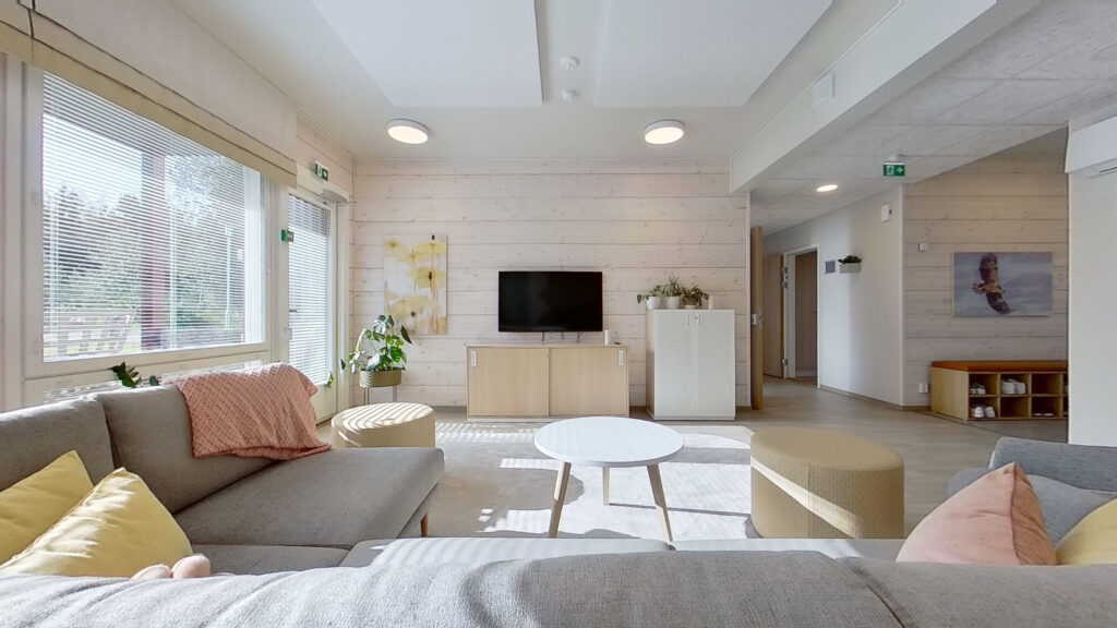 Stort och ljust vardagsrum med en stor soffa, soffbord och TV