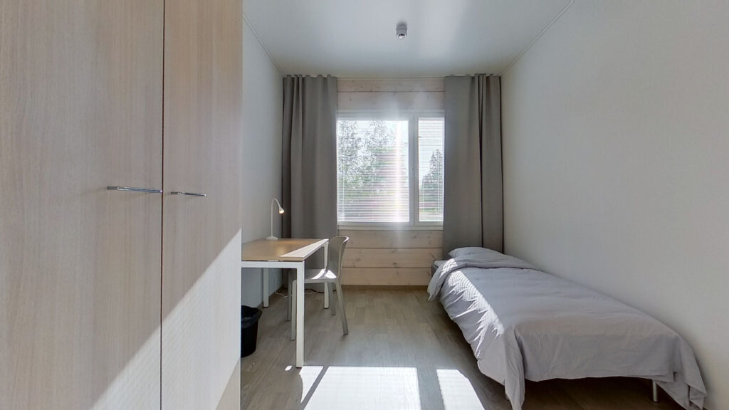 Ett bekvämt sovrum med säng, garderob och skrivbord