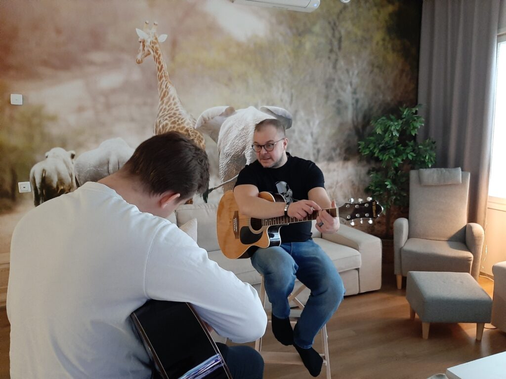 Kaksi henkilöä soittamassa kitaraa.