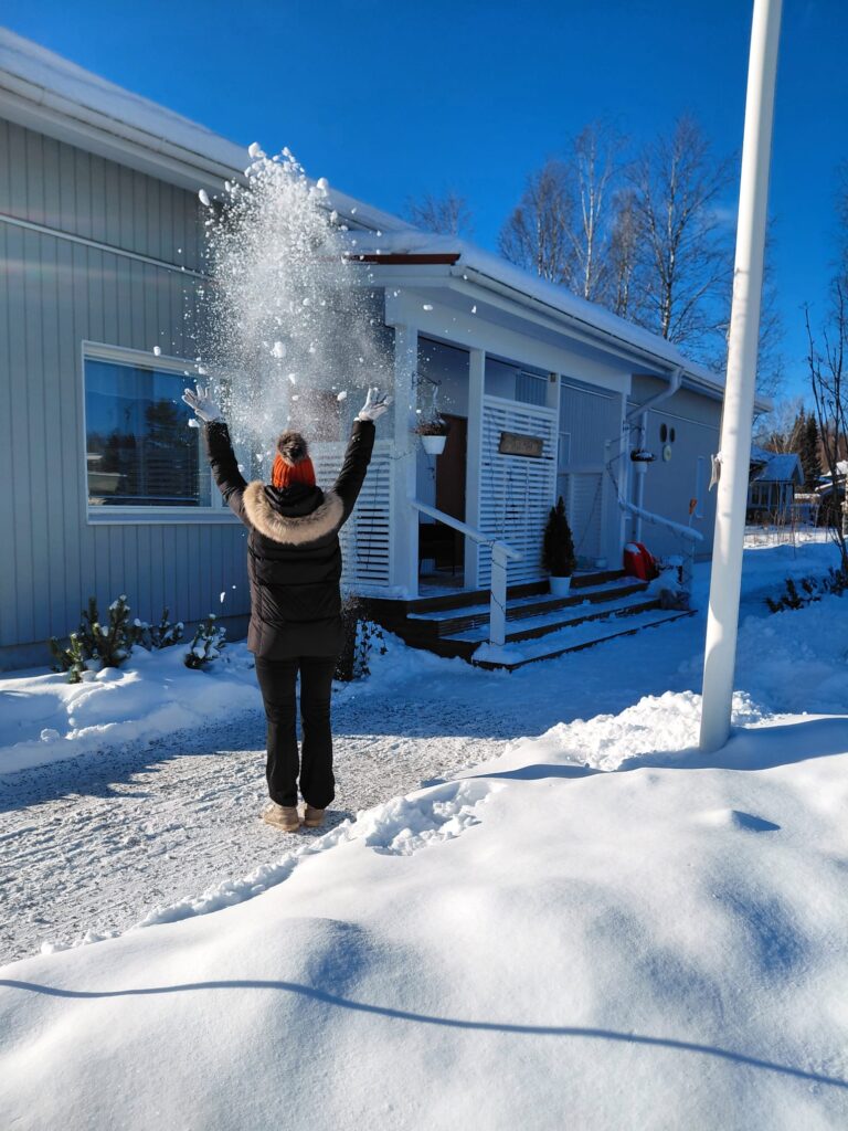 Henkilö heittää lunta ilmaan